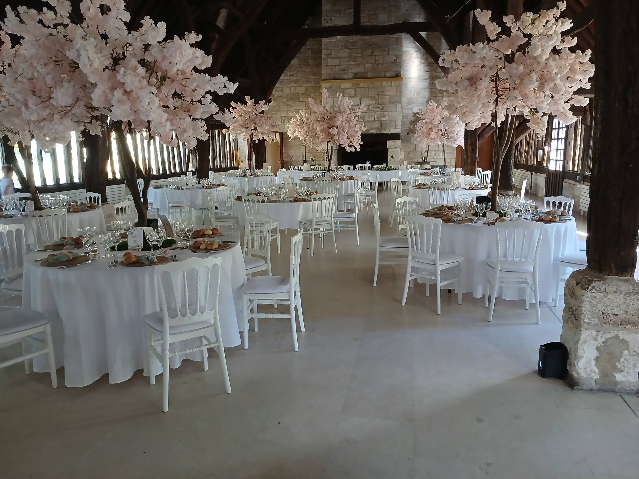 Salle de mariage fleurie avec tables rondes dressées